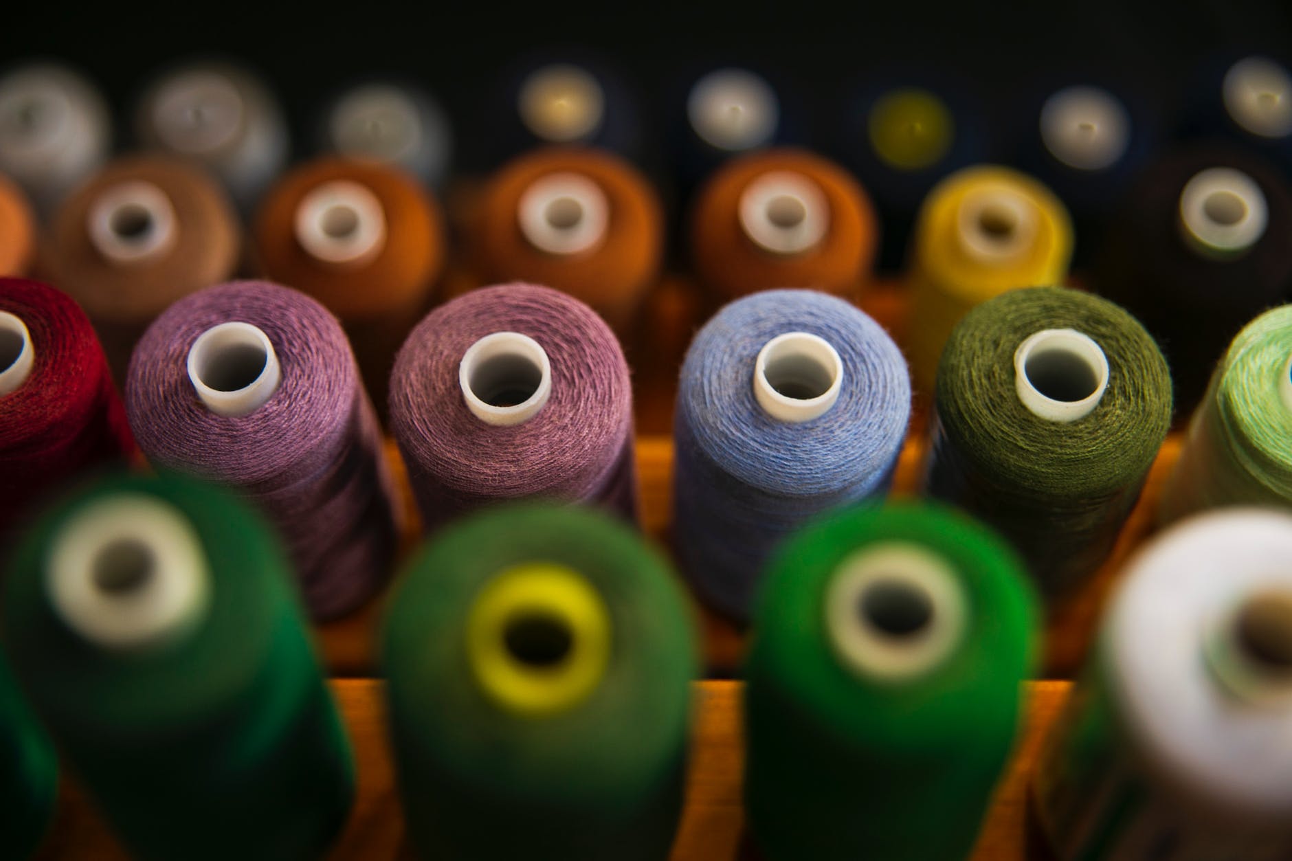 selective focus photography of assorted coloured thread spools